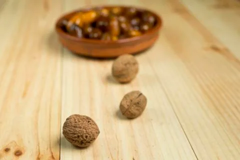Dice and nuts on a background of pine wood. Stock Photos