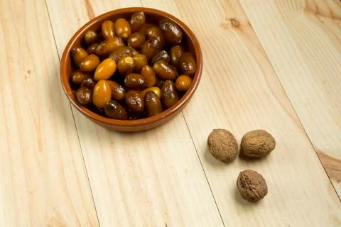 Dice and nuts on a background of pine wood. Stock Photos