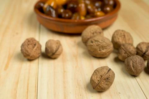 Dice and nuts on a background of pine wood. Stock Photos