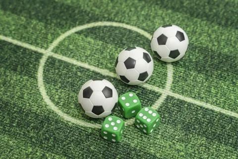 Dice and soccer ball on green grass, football sports betting concept Stock Photos