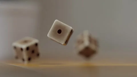 Dice cubes falling on a wooden table and bouncing Stock Footage 253561565