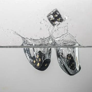 Dice drop in water Stock Photos