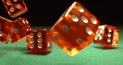 Dice fly and tumble toward the camera in extreme slow motion, landing on a .. Stock Footage 345584418