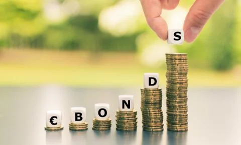Dice form the expression "-Bonds" on increasing high stacks of coins. Stock Photos