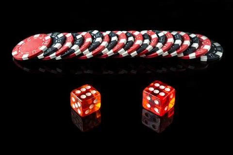 Dice with a maximum winning combination of twelve in poker on a black table Stock Photos
