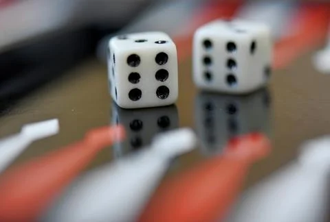 Dice playing on the backgammon board Stock Photos