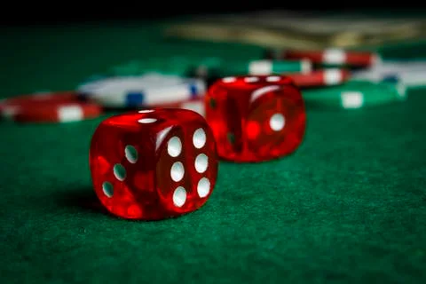 Dice on the poker table against the background of poker chips Stock Photos