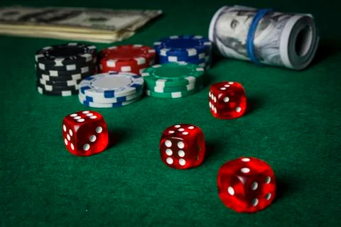 Dice on the poker table against the background of poker chips and dollars Stock Photos