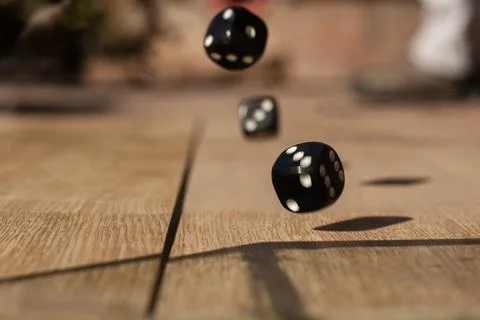 Dice rolling on a wooden surface Photos