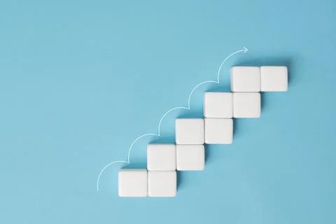 Dice stacking as step stair with white arrow up on blue background, Ladder .. Stock Photos