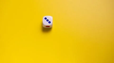 Dice on a yellow surface 스톡 사진