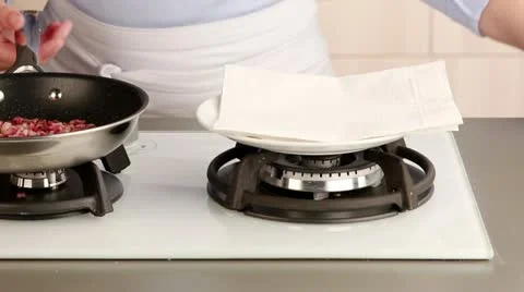 Diced bacon being removed from a pan and dried on kitchen paper Stock-Footage 24670079