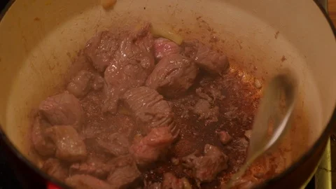 Diced beef being spooned out of a casserole dish Stock Footage 121449352