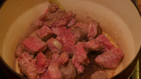 Diced beef cooking and being stirred in a casserole dish Stock Footage 121449400