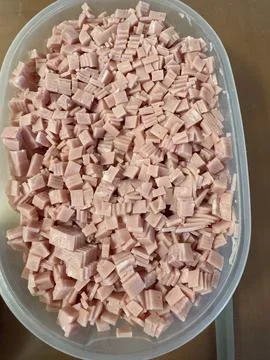 Diced ham pieces in a plastic container ready for cooking Stock Photos