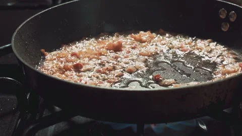 Diced pancetta sizzles and crisps in a skillet on a stovetop Vidéo 341292582