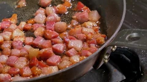Diced Pancetta Sizzling and Rendering in a Skillet on a Stovetop Stock-Footage 346662921