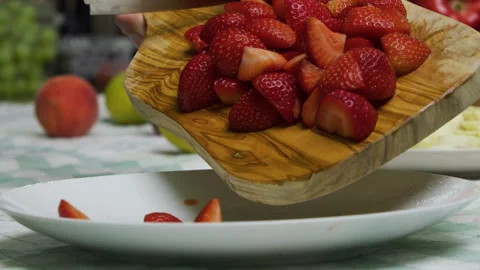 Diced strawberries rolling off chopping board onto plate in slow motion Stock Footage 341227676