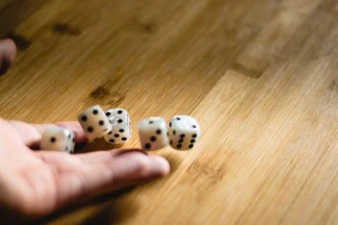 Dices bouncing on a wooden table. Single or group Stock Photos
