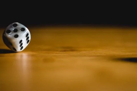 Dices bouncing on a wooden table. Single or group Stock Photos