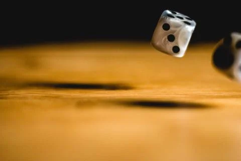 Dices bouncing on a wooden table. Single or group Stock Photos