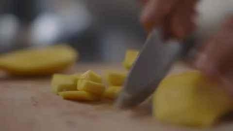 Dicing mango being into pieces with a knife on a cutting board Stock Footage 194478564