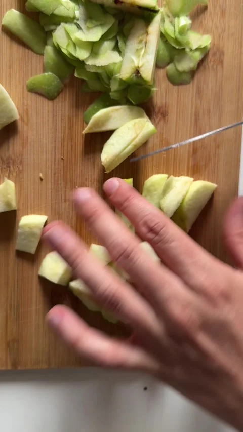 Dicing peeled green apple on cutting board for fruit salad Stock Footage 337482498