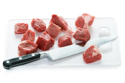 Dicing raw lamb with a kitchen knife Stock Photos