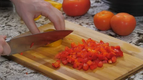 Dicing yellow and red peppers on kitchen wood cutting board 01 스톡 동영상 110885853