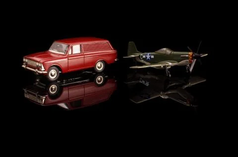 Die cast model car and model plane on the black reflective surface Stock Photos