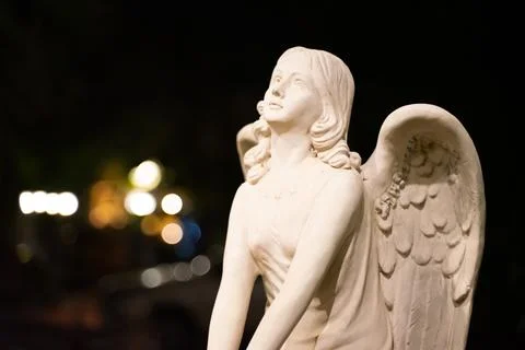 A die-cut cupid statue on a bokeh light background Stock Photos