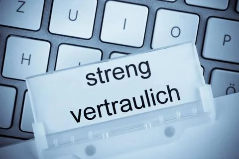 Die Mappe eines Hängeregisters vor einer Computertastatur zum Thema Streng.. Stock-Fotos