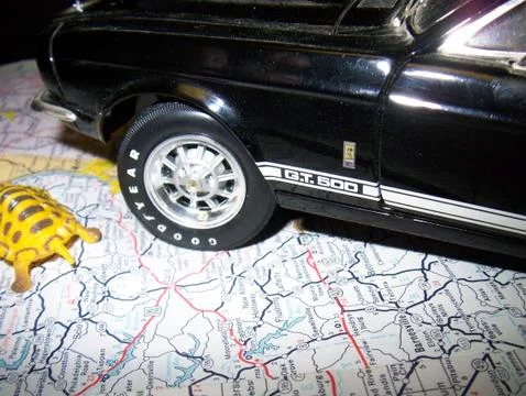 Diecast Car Sitting on Map Showing Travel Stock Photos
