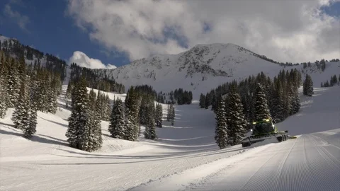 A diesel-electric Piston Bully snow groomer drives down the ski slope, Utah. Stock Footage 99809490