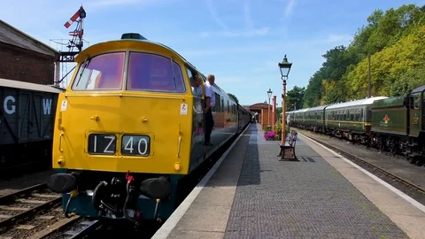 Diesel engine pulling steam train carriages country station Stock Footage 80316164