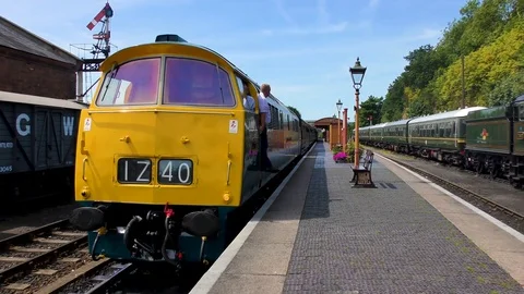 Diesel engine pulling steam train carriages country station Stock Footage 80317789