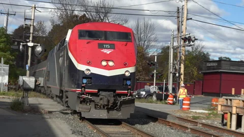 Diesel engine, whistle, Vermonter Amtrak train roars past, arrives station Stock Footage 320211280