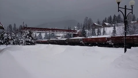 Diesel freight train with raw materials moves along winter village. Stock Footage 125197480