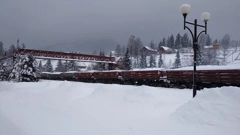 Diesel freight train with raw materials moves along winter village. Stock Footage 125197486