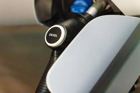 Diesel fuel pump nozzle inserted in vehicle fuel tank at gas station Stock Photos