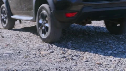 Diesel SUV reversing over small stones on rough terrain, vehicle moving backward Stock Footage 333617167