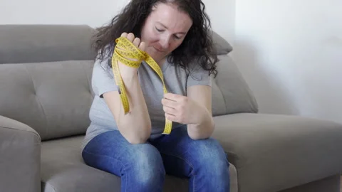 Diet complaining sitting in couch Vidéo 268060187