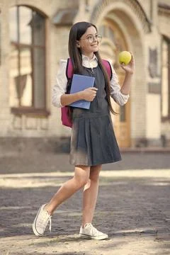 Diet makes difference to learning. Happy child hold apple and book. School break Foto stock
