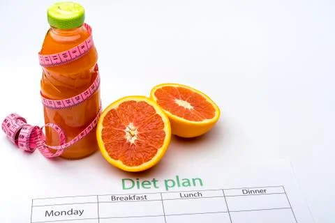 Diet plan and bottle of grapefruit juice with fresh grapefruit on white backg Stock Photos