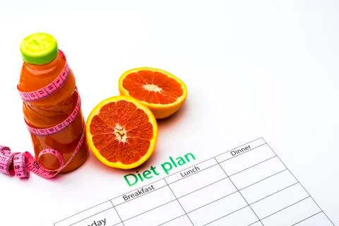 Diet plan and bottle of grapefruit juice with fresh grapefruit on white backg Stock Photos