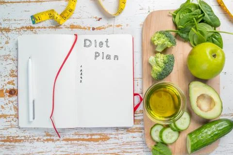 Diet plan concept - selection of green food and note pad Stock Photos
