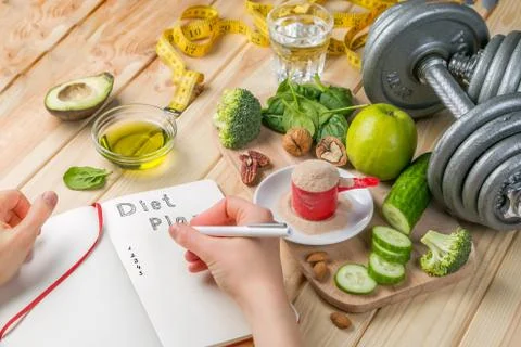 Diet plan concept - selection of green food and note pad Stock Photos