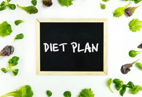Diet plan concept. Vegetable background. Spinach, lettuce, rucola and chalkbo Stock Photos