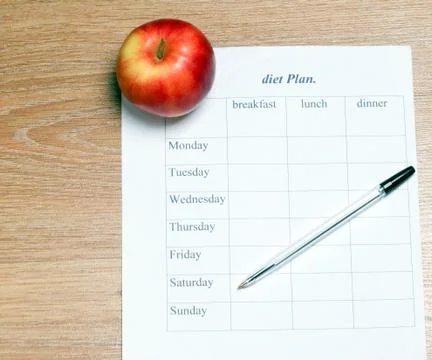 Diet Plan. diet plan, pencil and apple lying on a wooden surface. Stock Photos
