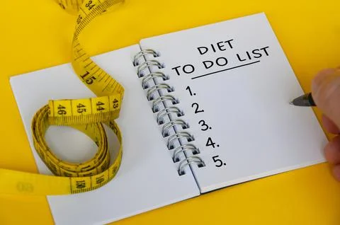Diet plan text on white notepad with measuring tape on yellow background. H.. Foto stock